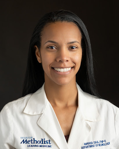 Headshot example photo of a woman in a white coat against a dark background
